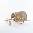 Wicker cart with wheels on a textured wall background